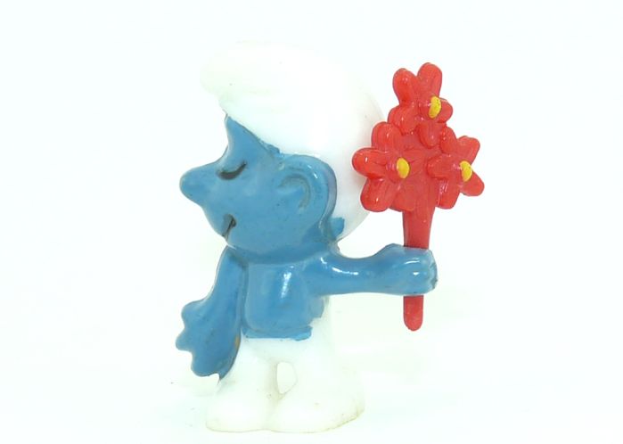 Der Schüchterne Schlumpf mit Blumenstrauß. Der Blumenstrauß hat einen dicken Stiel und eine Top Bemalung