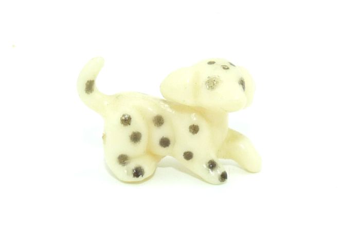 Kleine Hundefigur aus weißem Grundmaterial und mit schwarzen Punkten