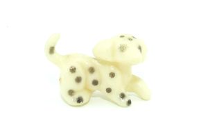 Kleine Hundefigur aus weißem Grundmaterial und mit schwarzen Punkten